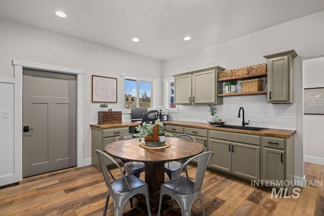 kitchen featuring butcher block countertops, open shelves, a sink, and wood finished floors