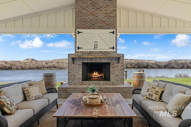 view of patio / terrace featuring an outdoor living space with a fireplace and a water view