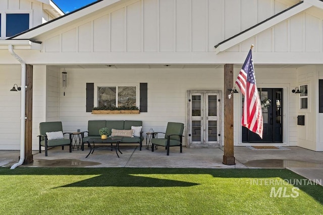 rear view of house with a yard, french doors, board and batten siding, and a patio