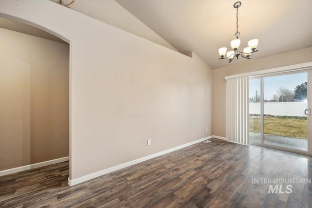 spare room featuring baseboards, lofted ceiling, a notable chandelier, and dark wood finished floors