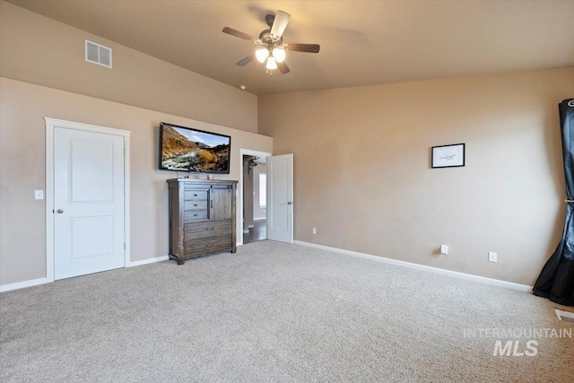 unfurnished bedroom with visible vents, baseboards, carpet, and vaulted ceiling