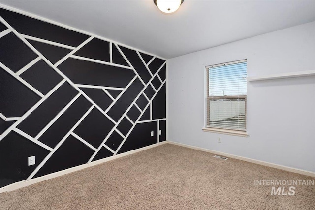 carpeted spare room featuring visible vents and baseboards