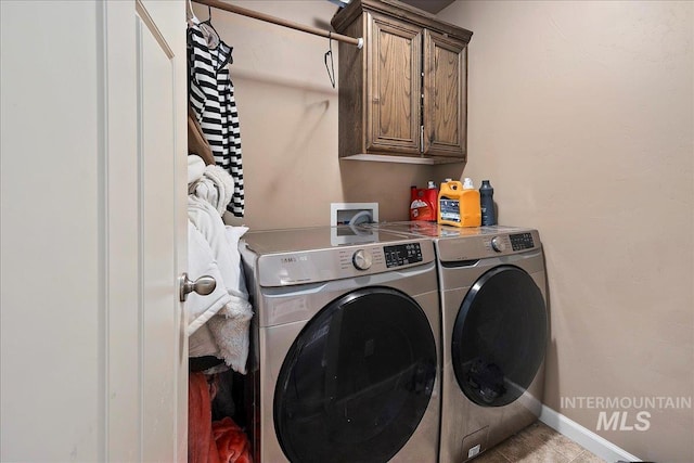 clothes washing area with washer and dryer, baseboards, and cabinet space