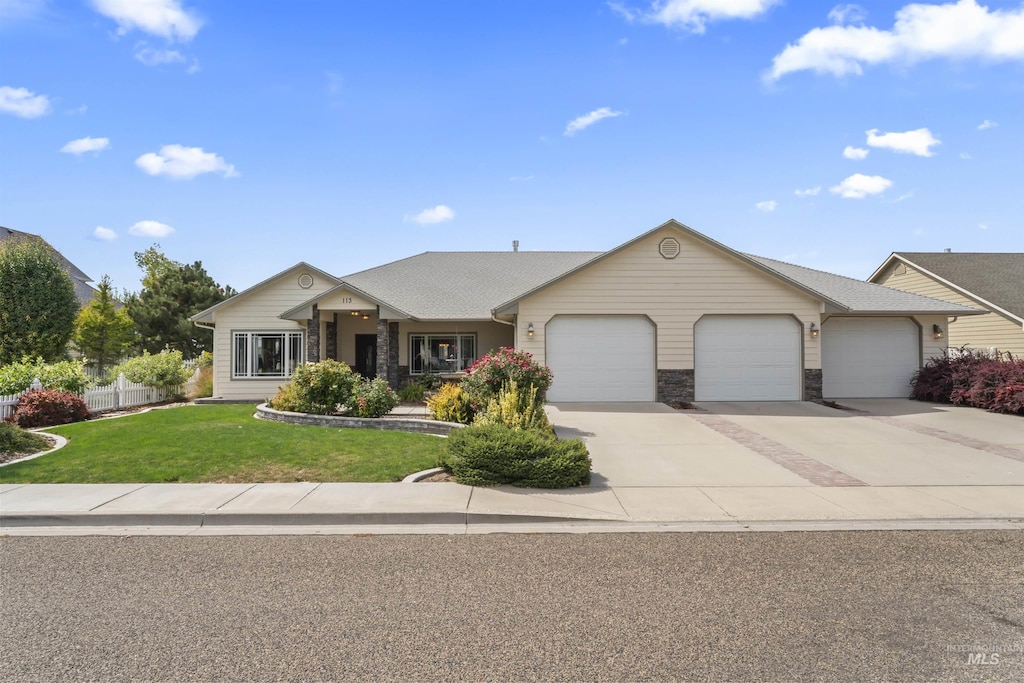 single story home featuring a front yard, stone siding, driveway, and an attached garage