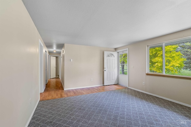 478AND716 Three Bear Rd, Kendrick, ID 83537 - empty room with wood finished floors, baseboards, a textured ceiling, and carpet flooring