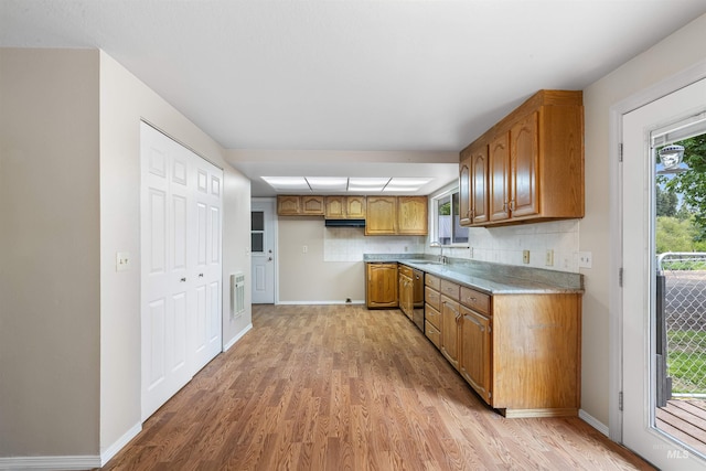 478AND716 Three Bear Rd, Kendrick, ID 83537 - kitchen with light wood finished floors, brown cabinetry, tasteful backsplash, and a sink