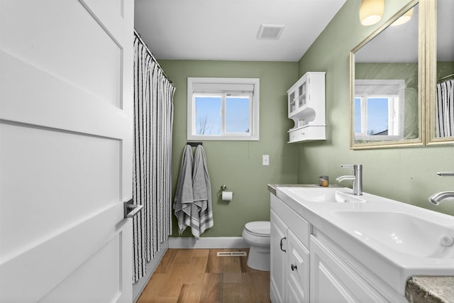 bathroom featuring wood-type flooring, vanity, and toilet