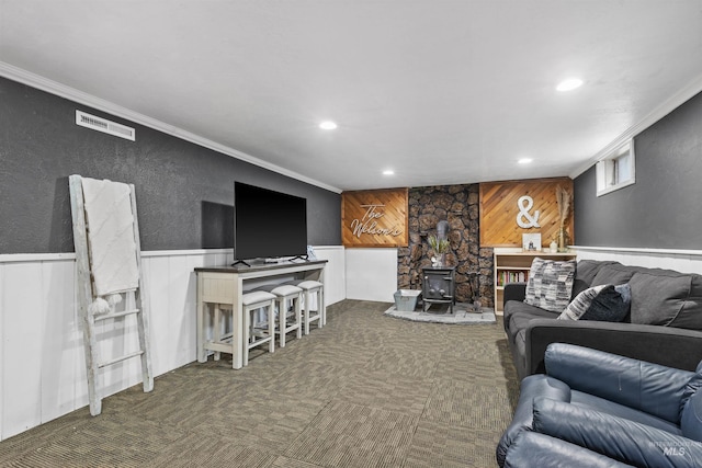 living room with dark colored carpet, a wood stove, and ornamental molding