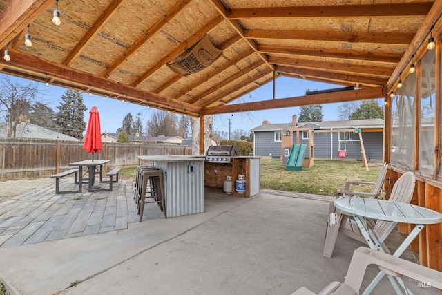 view of patio / terrace with a grill, a playground, and exterior bar