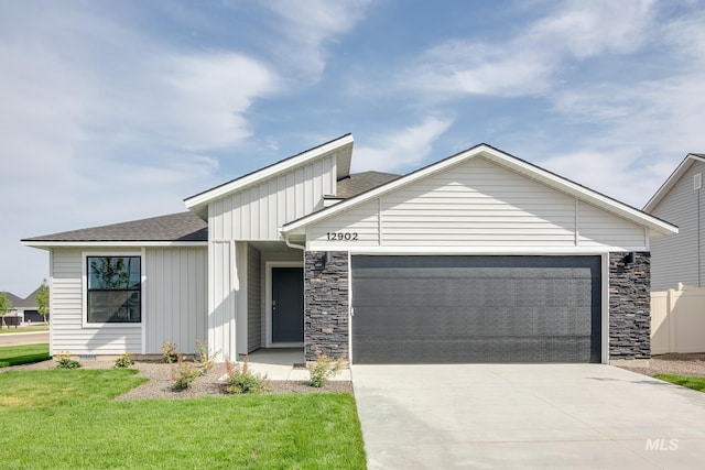 view of front of home featuring a shingled roof, concrete driveway, an attached garage, board and batten siding, and a front yard