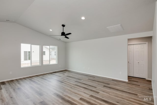 spare room featuring lofted ceiling, ceiling fan, and light wood-type flooring