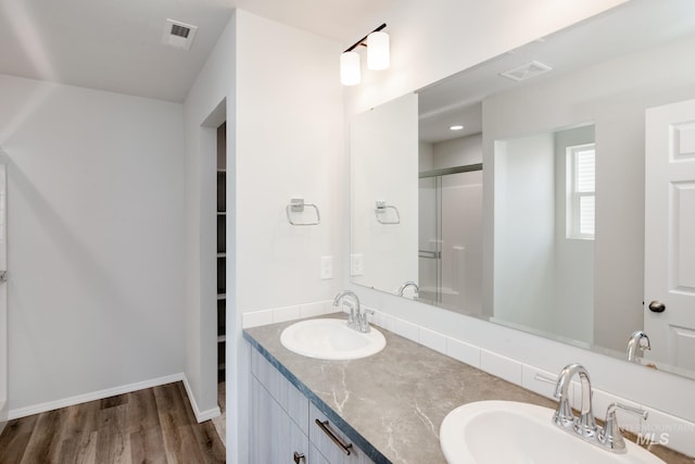 bathroom featuring hardwood / wood-style flooring, vanity, and an enclosed shower