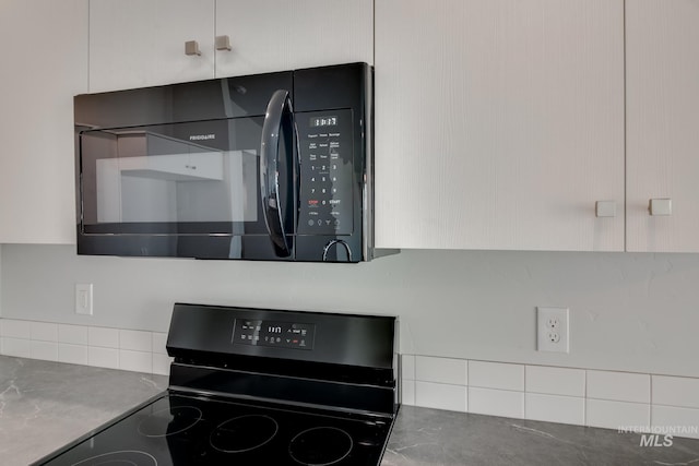 interior details featuring white cabinetry and black appliances