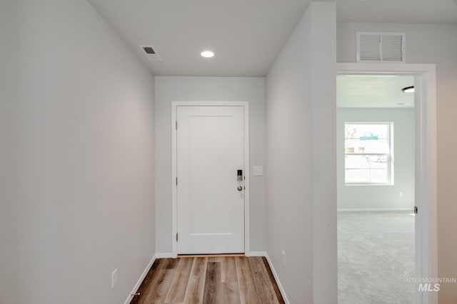 entryway featuring baseboards, visible vents, and wood finished floors