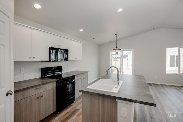 kitchen with lofted ceiling, light wood-style flooring, a sink, black appliances, and dark countertops