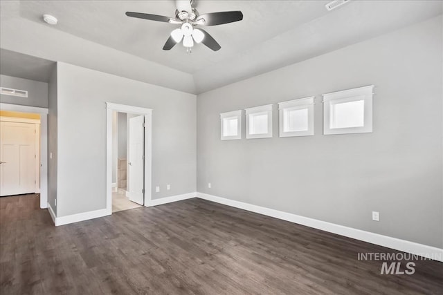 unfurnished bedroom featuring visible vents, dark wood finished floors, ensuite bath, and baseboards