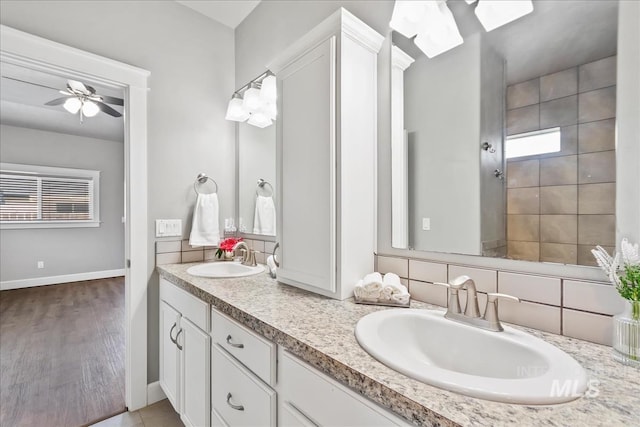 full bath with a healthy amount of sunlight, a ceiling fan, and a sink