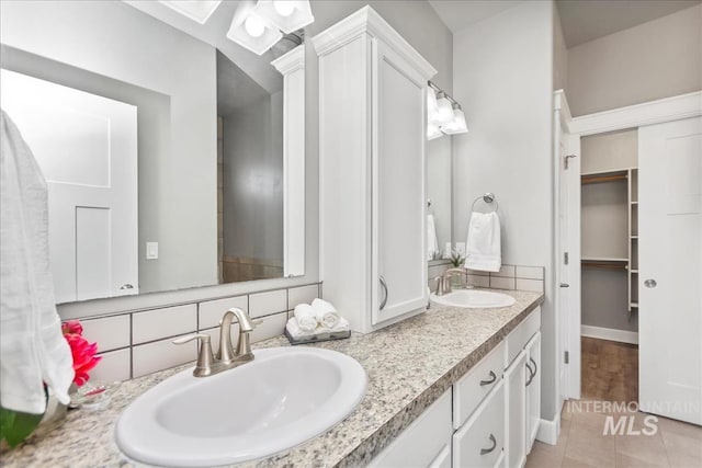 bathroom featuring double vanity, a sink, and tile patterned floors