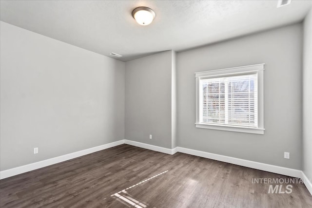 spare room with wood finished floors and baseboards