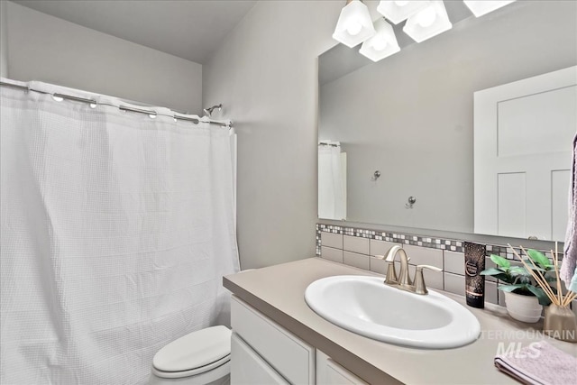 bathroom featuring toilet, vanity, and decorative backsplash