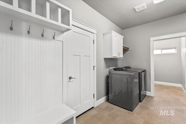 laundry area with cabinet space, visible vents, baseboards, and separate washer and dryer