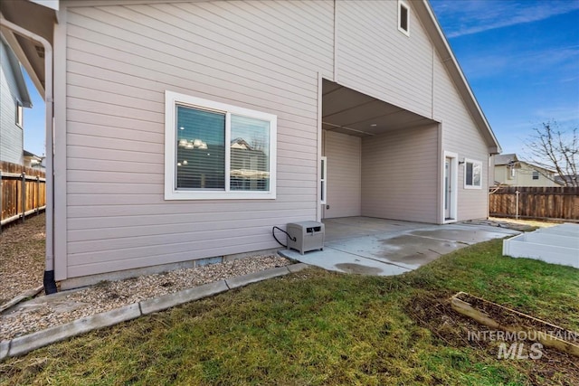 rear view of house with a patio area, fence, and a lawn