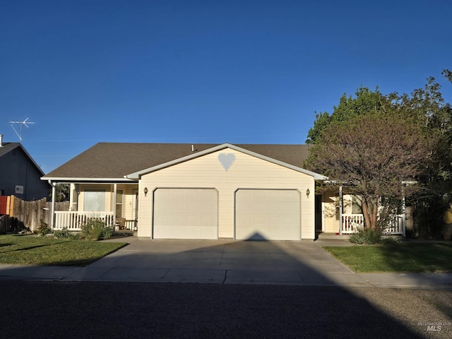 ranch-style home featuring driveway, fence, covered porch, an attached garage, and a front lawn