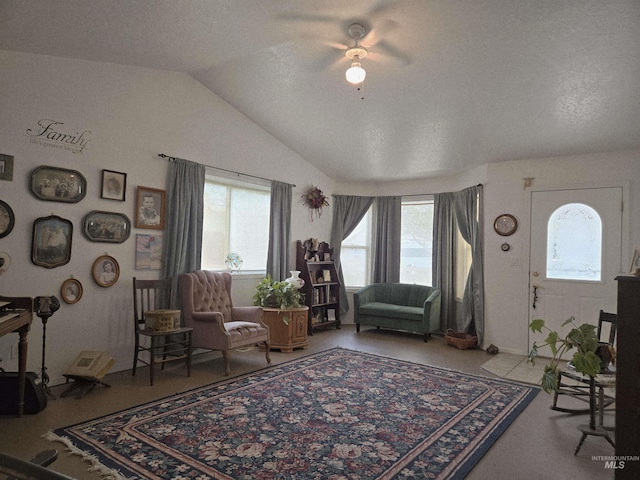 living area featuring vaulted ceiling, ceiling fan, and a healthy amount of sunlight