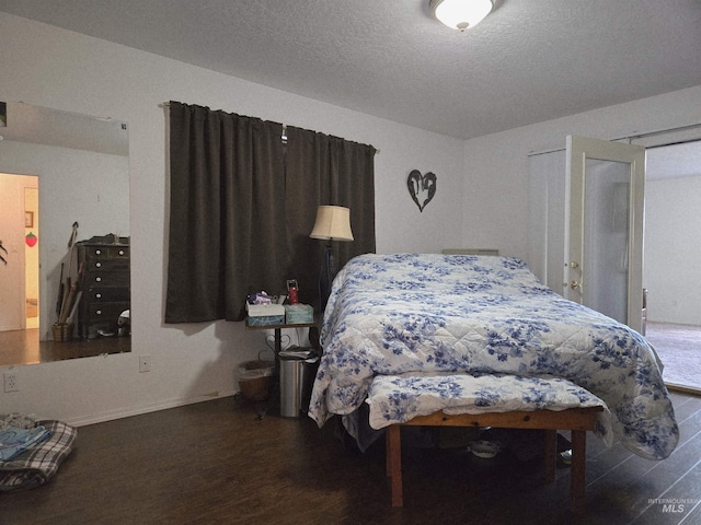 bedroom with a textured ceiling and wood finished floors