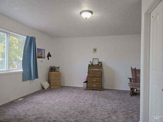 carpeted bedroom featuring a textured ceiling and visible vents