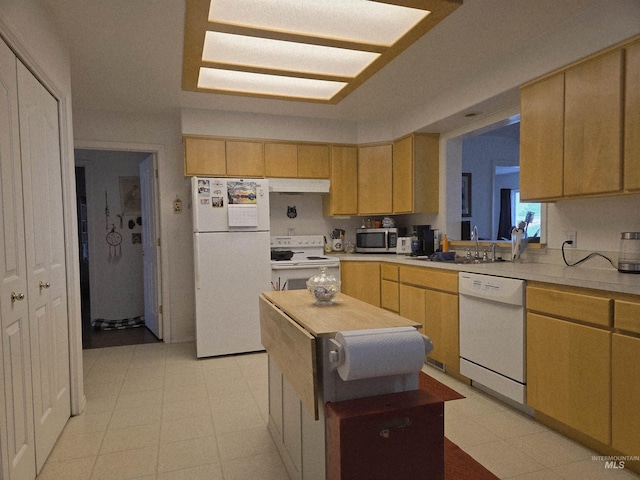kitchen featuring light floors, under cabinet range hood, white appliances, a sink, and light countertops