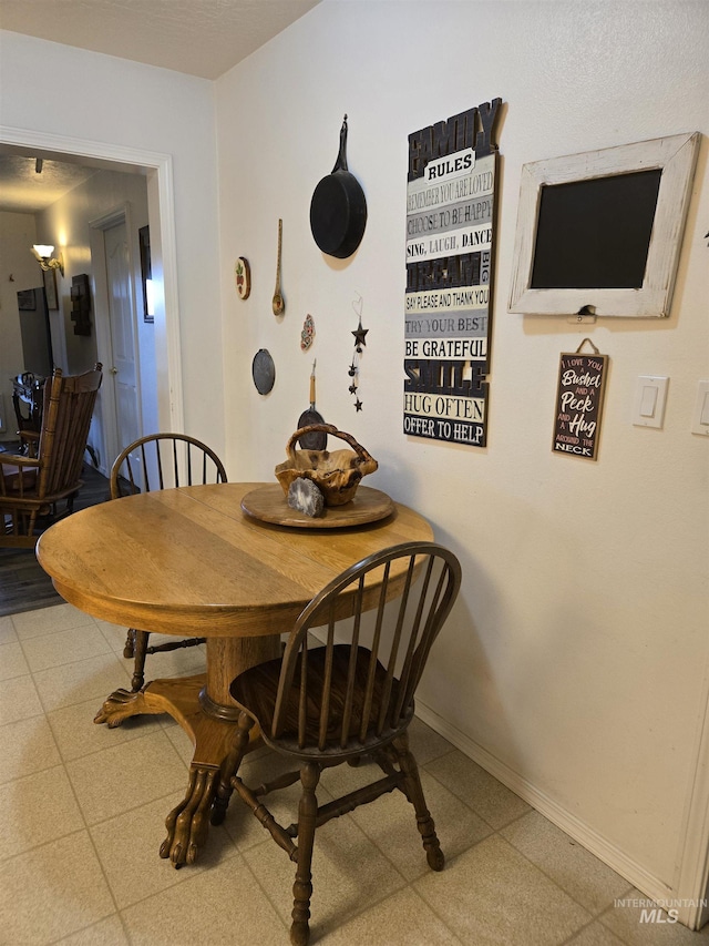 dining space with baseboards and tile patterned floors