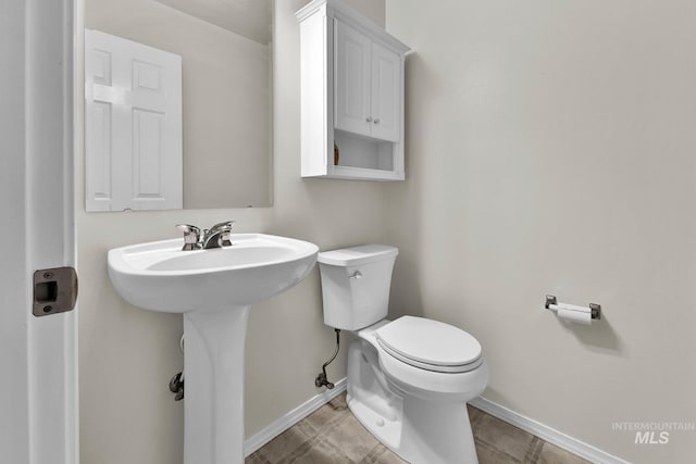 bathroom with toilet and baseboards