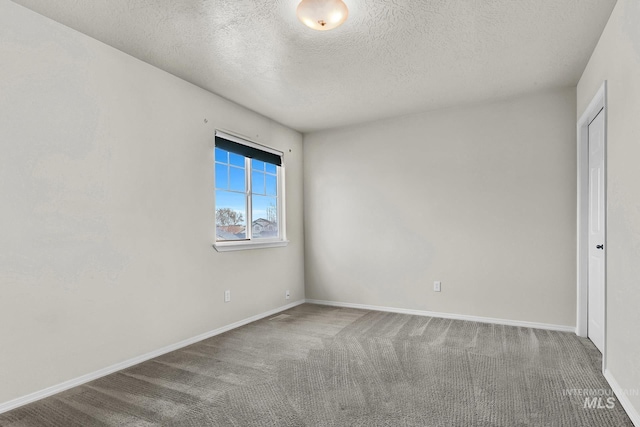 carpeted spare room with baseboards and a textured ceiling