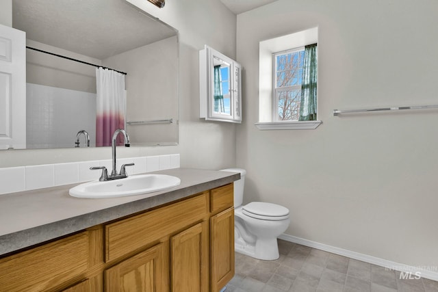 full bathroom featuring a shower with shower curtain, toilet, vanity, and baseboards