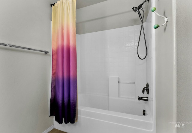 bathroom featuring shower / tub combo and baseboards