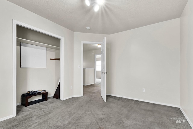 unfurnished bedroom with carpet, baseboards, and a textured ceiling