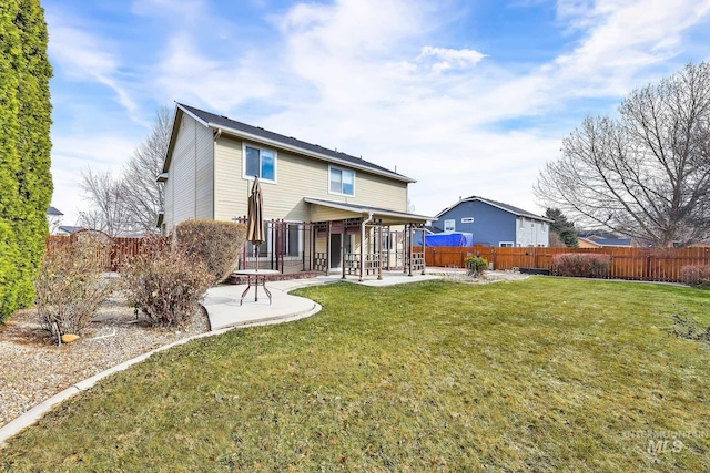 back of house with a fenced backyard, a lawn, and a patio