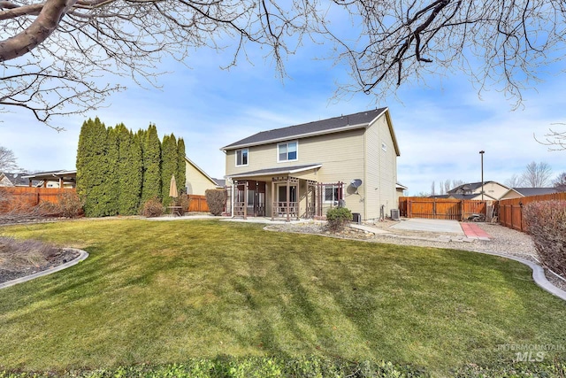 back of house with a yard, a patio area, and a fenced backyard