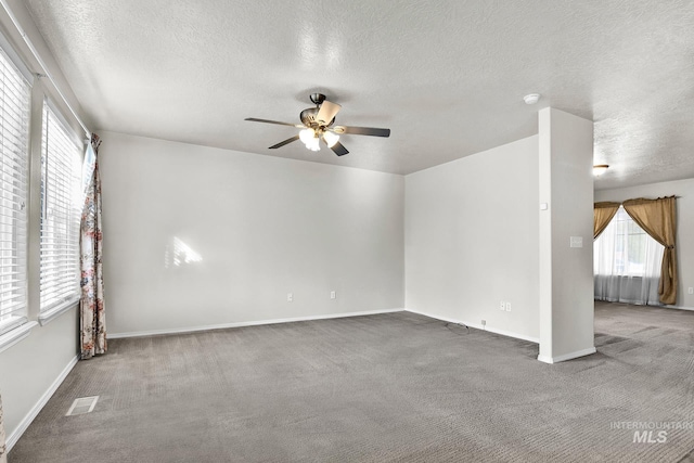 spare room featuring a ceiling fan, baseboards, visible vents, a textured ceiling, and carpet flooring