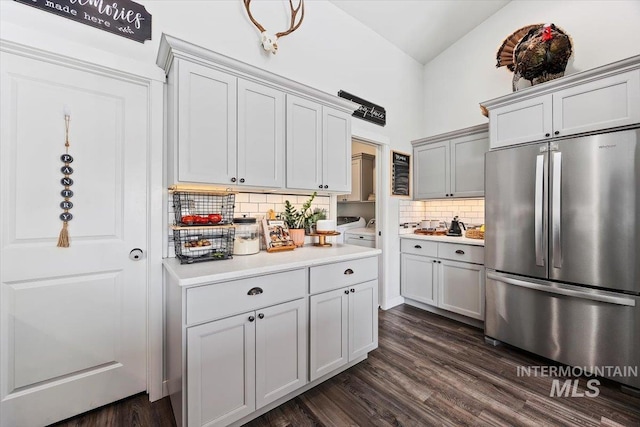 kitchen featuring decorative backsplash, stainless steel fridge, high vaulted ceiling, and dark wood-type flooring