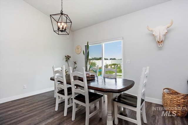 dining space with dark wood-type flooring and an inviting chandelier