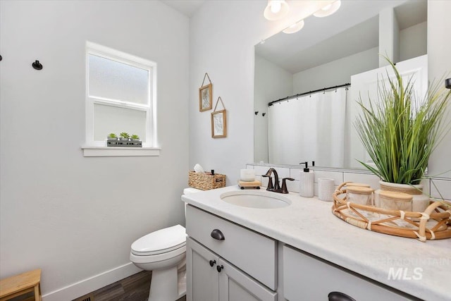 bathroom with hardwood / wood-style floors, vanity, and toilet