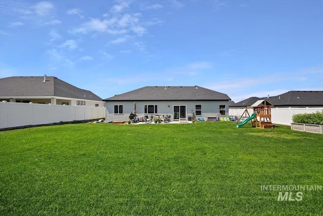 back of property featuring a playground and a lawn