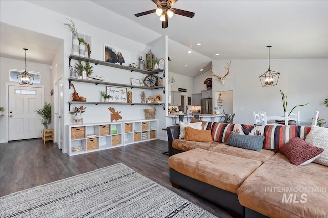 living room featuring ceiling fan with notable chandelier, high vaulted ceiling, and dark hardwood / wood-style floors