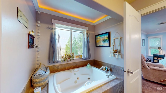 bathroom with ornamental molding, visible vents, a tub with jets, and a wealth of natural light