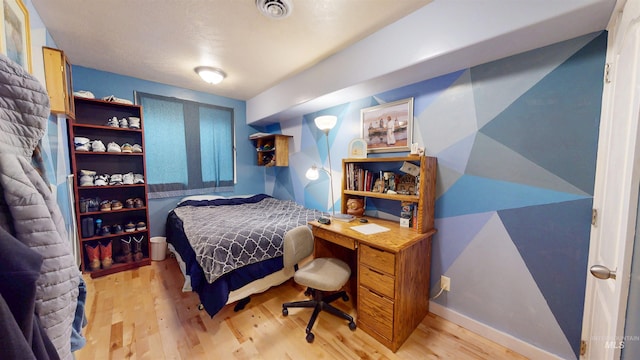 bedroom with visible vents and wood finished floors