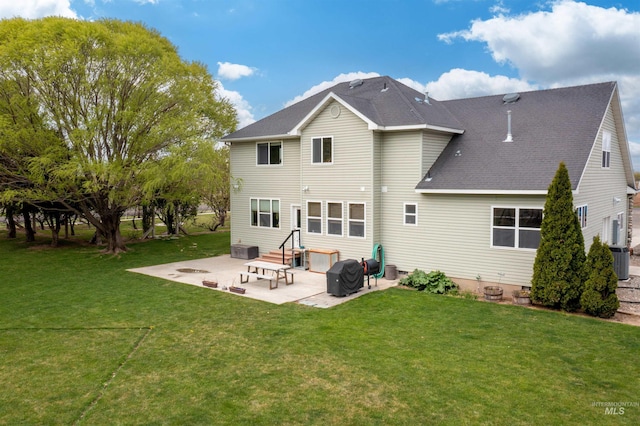 rear view of house with a lawn, a patio, a shingled roof, and central AC