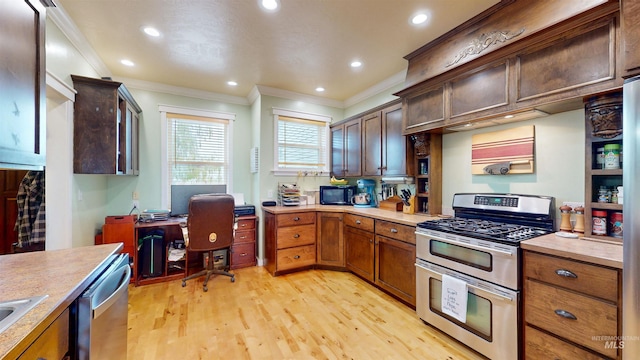kitchen featuring crown molding, light countertops, stainless steel appliances, and light wood-type flooring