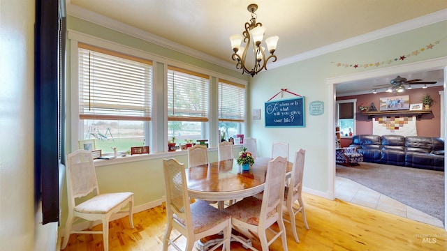 dining space with crown molding, baseboards, and light wood-type flooring